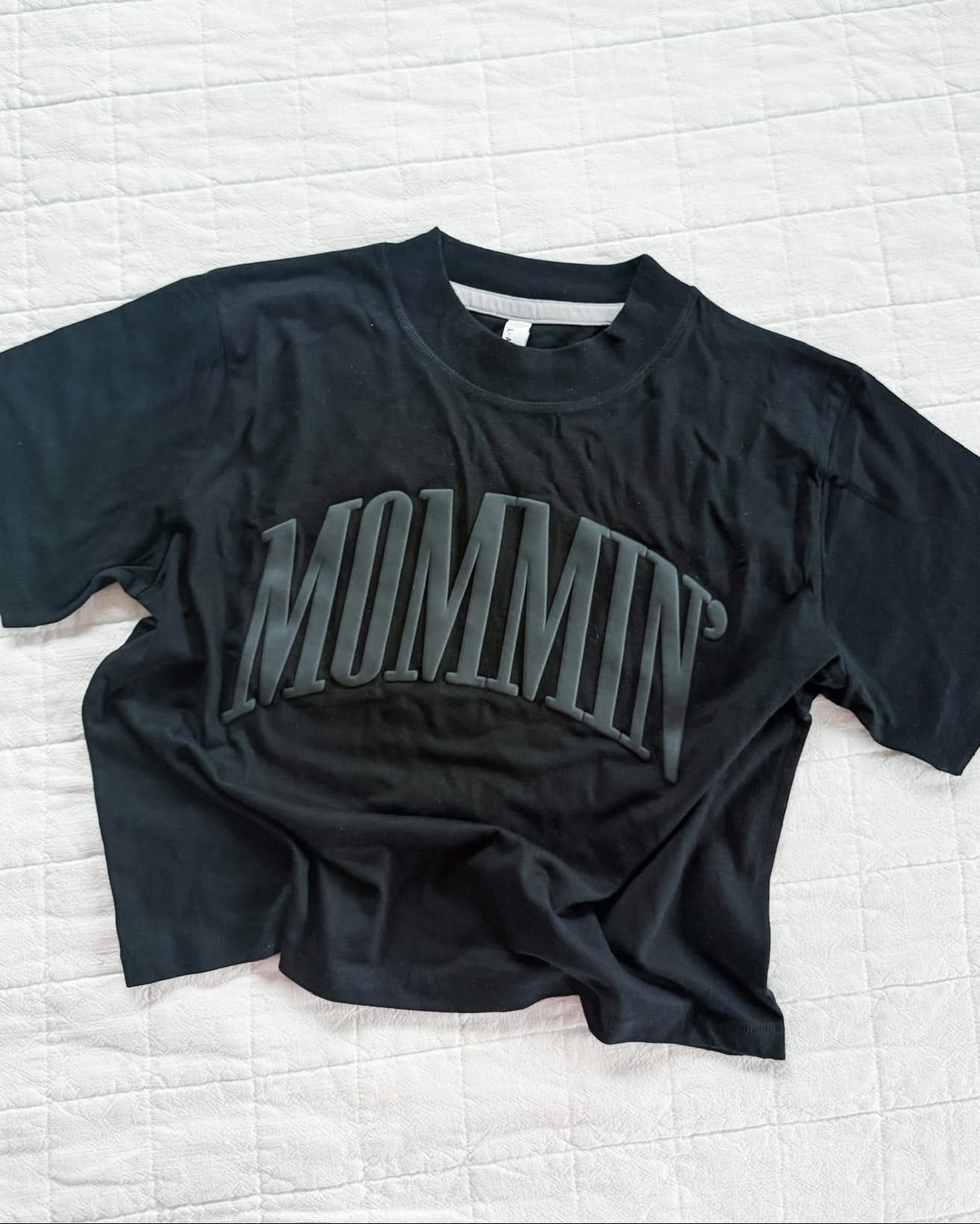 Adult boxy tee in black with 'mommin' printed on the front in puff print, seen on flat lay - Little Mama Shirt Shop