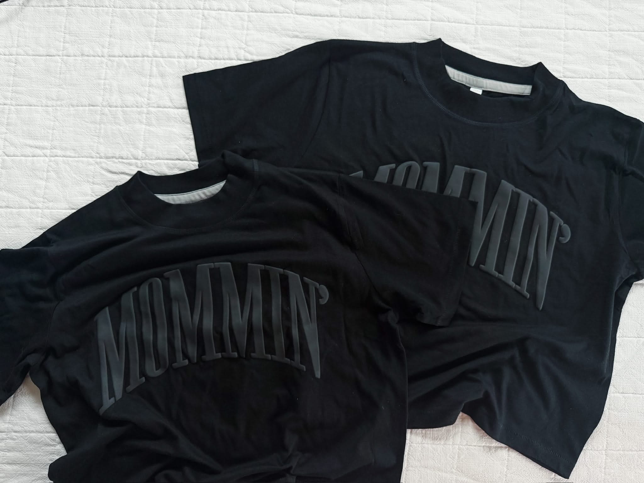 Adult boxy tee in black with 'mommin' printed on the front in puff print, seen on flat lay - Little Mama Shirt Shop